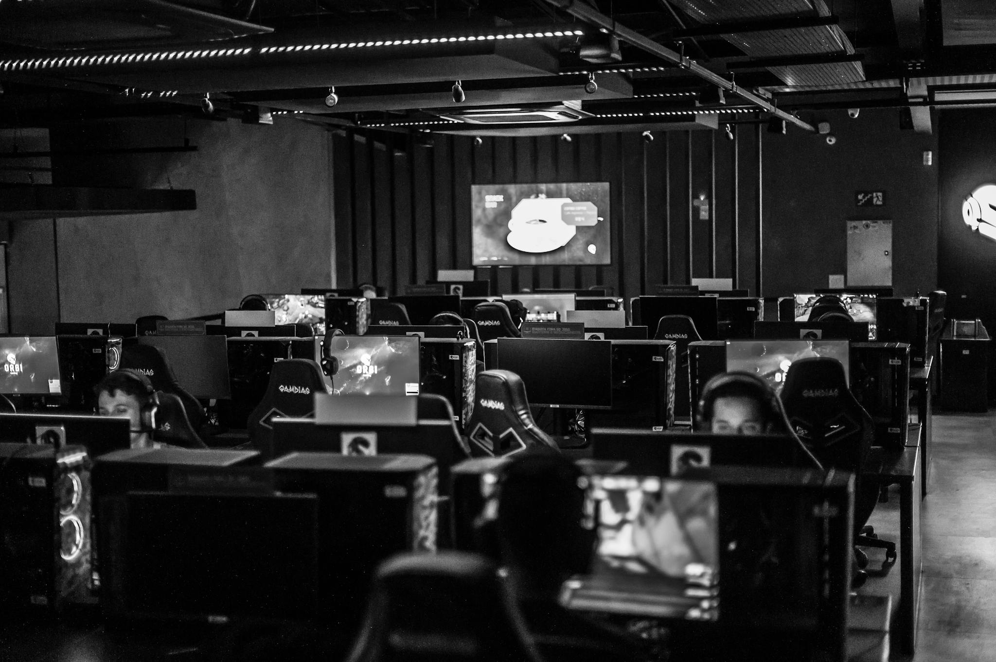 Black and white view of an active esports gaming studio with players immersed in video games.