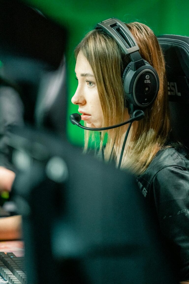 Young female gamer intensely focused during an esports competition wearing a headset.