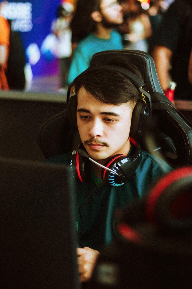 Young male gamer intensely focused at an esports tournament, wearing headphones.